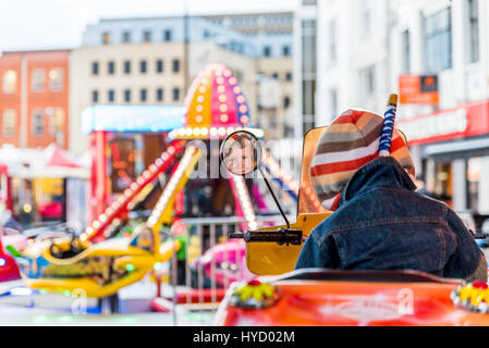 Boy having fun on ride at amusements park. Stock Photo