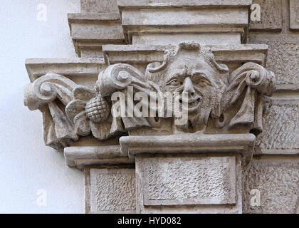 Castle building is decorated with carved stone face. Stock Photo
