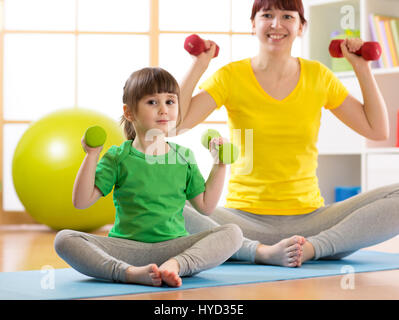 Woman and her child daughter doing fitness exercises with dumbbells Stock Photo