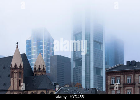 , Germany, Hesse, Frankfurt, St. Leonhards church in front of the skyscrapers of the financial district, fog. Stock Photo