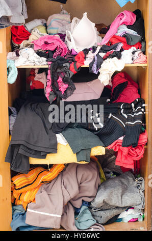 Pile of carelessly scattered clothes in wardrobe Stock Photo