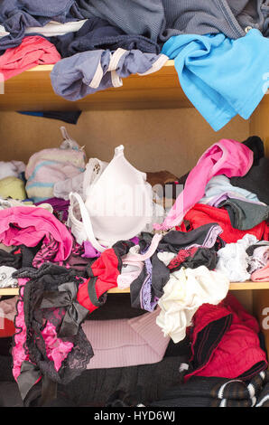 Pile of carelessly scattered clothes in wardrobe Stock Photo