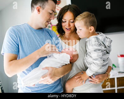 Mother and father carrying son (4-5) and daughter (0-1 months) Stock Photo