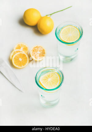 Detox lemon water in glasses served with fresh lemon fruits Stock Photo