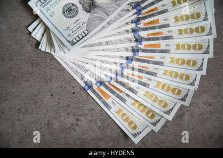 A stack of new one hundred dollar bills in US currency fanned out flat on a table Stock Photo