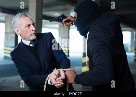 Aggressive hardened criminal holding the rope Stock Photo