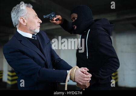 Greedy strong robber demanding money Stock Photo