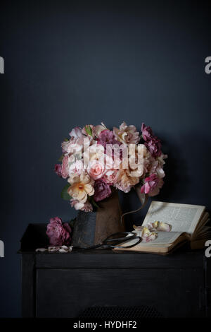 Collection iof pastel coloured roses in rustic setting. Still life image, window light. Stock Photo
