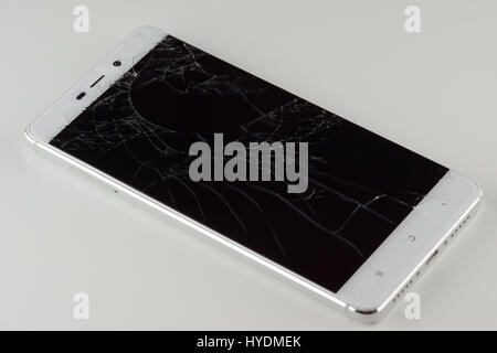 White mobile phone with a broken screen Stock Photo