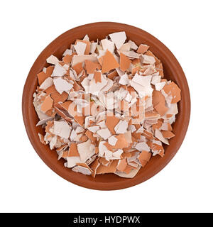 Top view of a small bowl filled with crushed egg shells isolated on a white background. Stock Photo