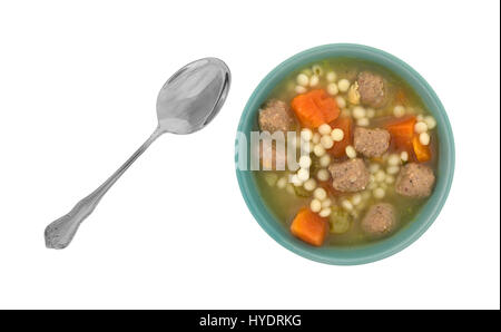 Top view of a bowl filled with Italian style wedding soup with a spoon to the side isolated on a white background. Stock Photo