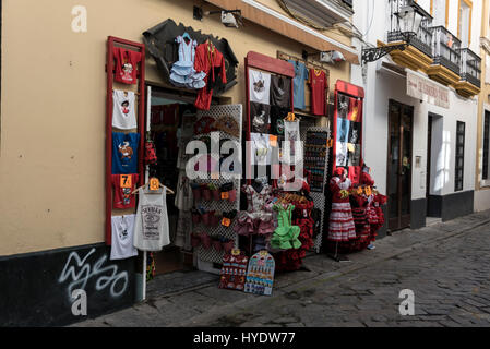 A variety of child flamenco dresses and other souvenirs on sale in one of the many Spanish souvenir shops in Seville Old Town, Seville, Spain. Stock Photo