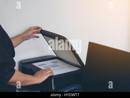 Businesswomen use printer copy chart business report. soft flare filter. Stock Photo