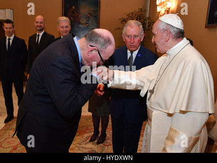 The Sun royal photographer Arthur Edwards kisses the hand of Pope Francis at the Vatican during a visit by The Prince of Wales (centre). Stock Photo