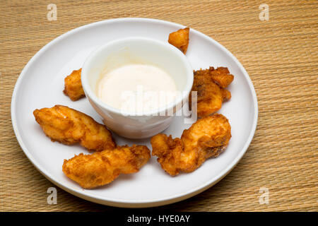 deep fried grouper fingers on white plate with dipping sauce Stock Photo