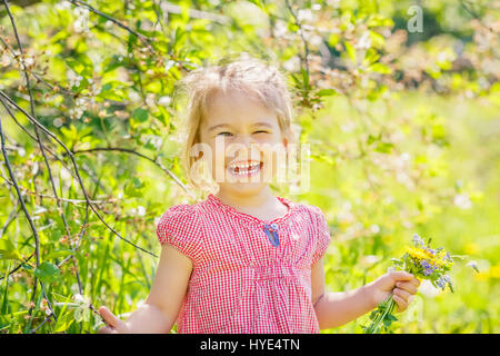 Happy little girl in spring sunny park Stock Photo