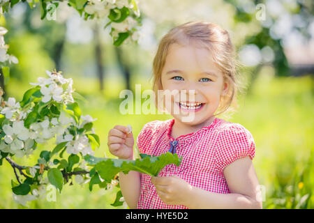 Happy little girl in apple tree garden Stock Photo