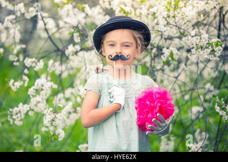 Funny girl in hat and gloves and with fake mustache. Stock Photo