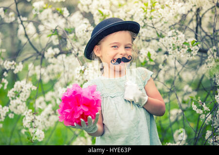 Funny girl in hat and gloves and with fake mustache. Stock Photo