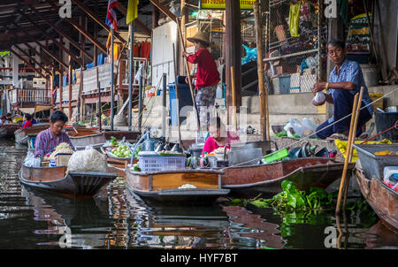 DAMNOEN SADUAK, THAILAND - CIRCA SEPTEMBER 2014: People and boats in the Damnoen Saduak floating market in the central region of Thailand. Stock Photo