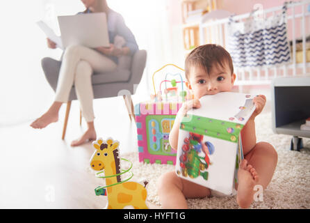 Toddler playing with toys in the room Stock Photo