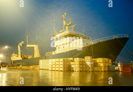 Fishing trawler ship at dock by night in drizzling rain Stock Photo