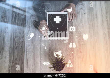 doctor working with digital tablet computer and stethoscope on wooden desk at hospital with virtual icons screen interface Stock Photo