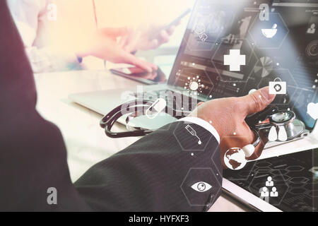 Medical co working concept,Doctor working with smart phone and digital tablet and laptop computer to meeting his team in modern office at hospital wit Stock Photo