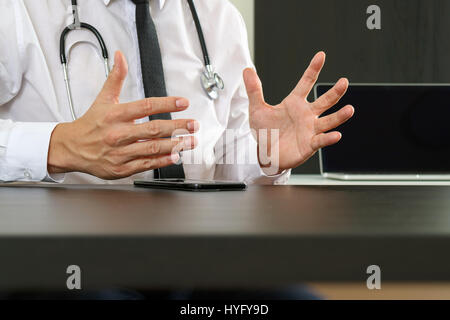 smart medical doctor working with smart phone and digital tablet computer and stethoscope on wood desk in modern office Stock Photo