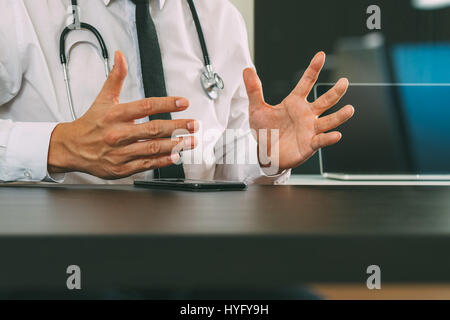 smart medical doctor working with smart phone and digital tablet computer and stethoscope on wood desk in modern office Stock Photo