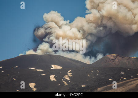 SICILY, ITALY: MOUNT Etna has been photographed exploding into life during its most recent eruption yesterday. Pictures show smoke billowing out from the top of the active volcano during the day. Other Images show Etna at night with glowing red molten lava trailing down the mountainside. The images were captured by local photographer Marco Restivo. Stock Photo