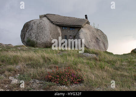 FAFE MOUNTAINS, PORTUGAL: COULD this real-life Flintstones house be the most impregnable yet bizarre on the planet? Nestled between four mighty granite boulders, two-thousand six hundred feet high in the Fafe Mountains in Portugal, this extraordinary dwelling with bullet-proof doors and windows is known as ‘Casa do Penedo’ or ‘House of Stone’. Portuguese photographer Ricardo Oliveira Mateus (34) was able to reach this house of rock and snap the unusual character of this sixteen and a half feet tall former holiday home. Stock Photo