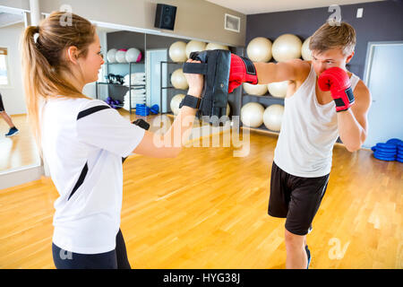 Boxer Punching Bag Held By Instructor In Gym Stock Photo