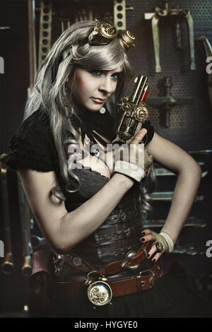 Portrait of steampunk woman with gun. Mechanical background Stock Photo