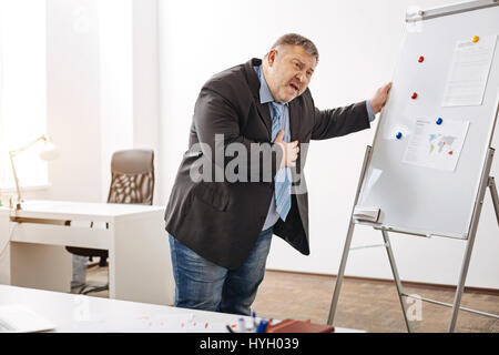 Hard working businessman having a heart stroke Stock Photo