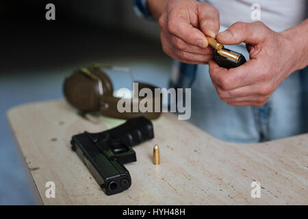 Close up of a bullet being put into the cartridge clip Stock Photo