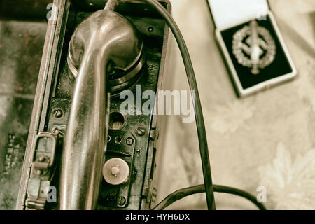 Army field telephone next to a German army medal, vintage Stock Photo