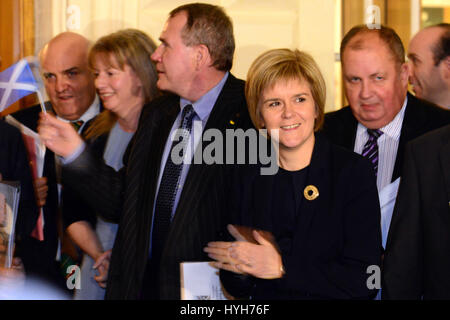 Nicola Sturgeon (foreground) waits with Scottish ministers and MSPs to bid farewell to Alex Salmond as he leaves the Scottish Parliament for the last time as First Minister Stock Photo
