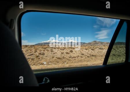 Snow capped mountain range taken from inside moving car Stock Photo