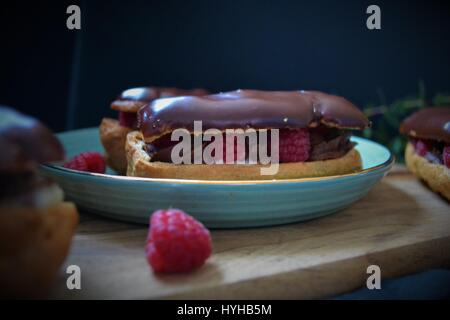 French Eclairs with Raspberries and Chocolate Swiss buttercream Stock Photo