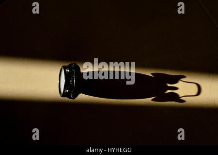 Sunlight beam hitting an Alarm Clock and projecting its shadow on the ground - Colors version Stock Photo