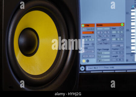 Close up shot of an audio speaker, with music production software in the background Stock Photo