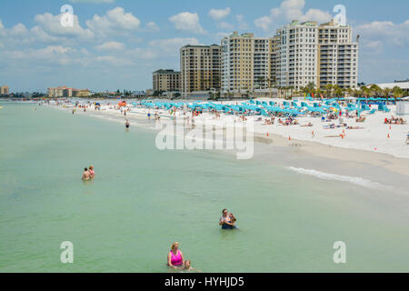 Long overview of people strolling, wading, swimming, sunbathing  & enjoying the white sand and turquoise waters of Clearwater Beach, FL, on he Gulf of Stock Photo