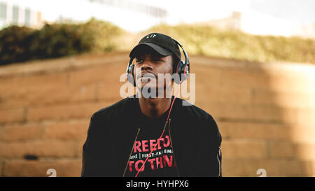 Portrait of a young man in a hat with headphones on looking to the side Stock Photo