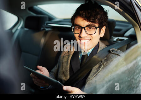 Young Businessman Using Tablet in Car Stock Photo