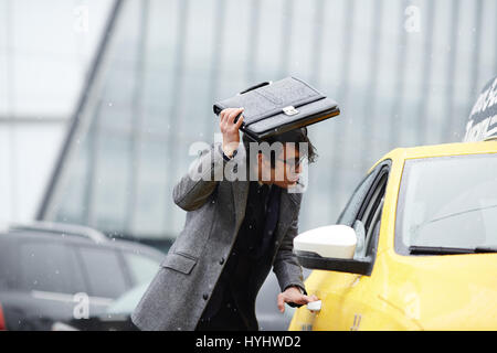 Businessman Catching Taxi in Storm Stock Photo