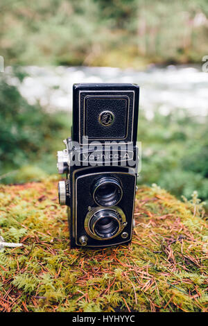 BELKNAP, OR - APRIL 24, 2015: Yashica A TLR medium format camera propped outdoors on a mossy rock with the McKenzie River of Oregon in the background. Stock Photo