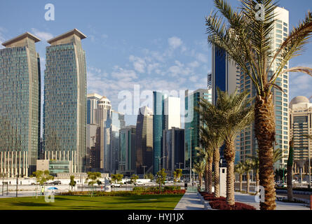 DOHA, QATAR - FEBRUARY 17, 2016: The high-rise district of Doha, seen from the road through the recently completed Hotel Park, and date palms in the f Stock Photo