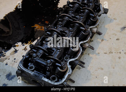 The head of the block of cylinders. The head of the block of cylinders removed from the engine for repair. Parts in engine oil. Car engine repair in t Stock Photo