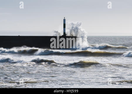 Aberystwyth Wales UK, Tuesday 04 April 2017 UK Weather: Blustry cold northerly winds whip up the waves crashing into the promenade under blue skies in Aberystwyth on the west Wales coast Credit: keith morris/Alamy Live News Stock Photo